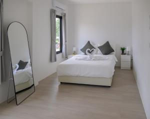 a white bedroom with a bed and a mirror at Zen Beach Lake Villa 3 - orchid villa in Haad Chao Phao +18 photos