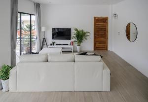 a white living room with a white couch at Zen Beach Lake Villa 3 - orchid villa in Haad Chao Phao