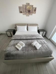 een slaapkamer met een groot bed met twee handdoeken bij Pino s house in Inveruno