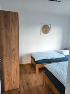 a room with two beds and a wooden door at SeeZeitApartments Whg 4 in Lembruch
