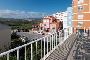a balcony with a view of a street and buildings at Carregado Second Floor in Carregado