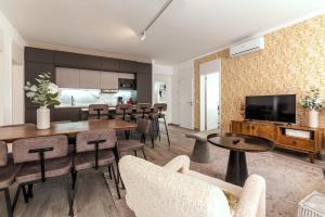 a living room with a table and chairs and a television at Carregado Second Floor in Carregado