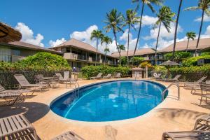 a pool with chairs and palm trees in a resort at Kaanapali Maui at the Eldorado by OUTRIGGER in Lahaina