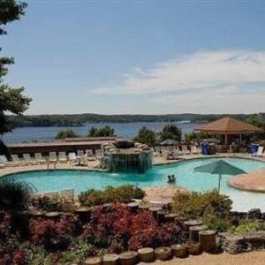 a large swimming pool with a view of a lake at Fairway to Heaven at Four Season 2BED2BATH Condo in Lake Ozark