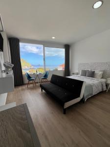a bedroom with a bed and a table and chairs at Feeling Like Home Machico in Machico
