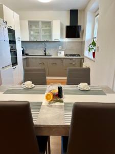a kitchen with a table with chairs and an orange on it at Apartment with garage and garden 