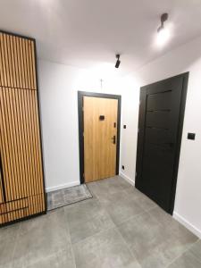 an empty room with two doors and a tile floor at Loft Re Design Apartament in Głogów