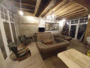 a living room with a couch and chairs and a christmas tree at Duo La belle échappée & Romance in Poperinge