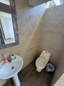 a bathroom with a toilet and a sink at Hotel El Alero in Chimaltenango +3 photos