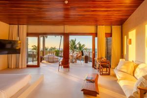 een woonkamer met een bank en uitzicht op de oceaan bij Casa Siará Preá in Prea