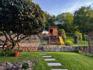 a garden with a playground and a tree at Baťovský dům ZLÍN in Zlín