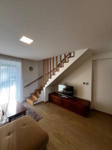 a living room with a couch and a staircase at Baťovský dům ZLÍN in Zlín