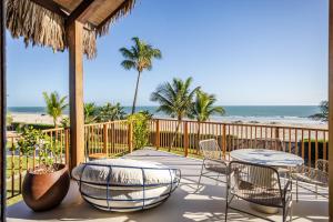 een patio met tafels en stoelen en het strand bij Casa Siará Preá in Prea