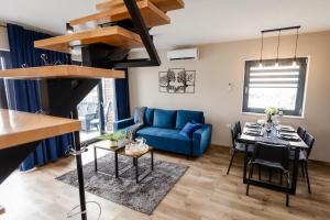 a living room with a blue couch and a table at Domki Pod Łysicą- basen jacuzzi sauna in Krajno Pierwsze