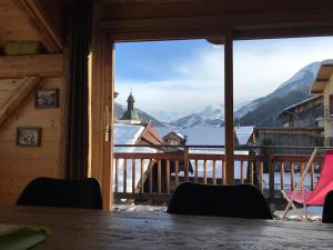 a room with a balcony with a view of a mountain at Chalet Lucien, Jacuzzi, Les 3 Vallées in Villarly
