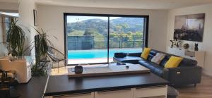 a living room with a couch and a large window at Architect-designed villa, overlooking Agay Bay in Saint-Raphaël