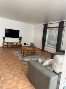 een woonkamer met een bank en een flatscreen-tv bij House in Alcobaça in Alcobaça
