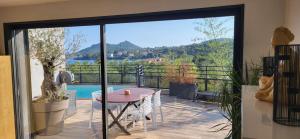 a balcony with a table and a view of the water at Architect-designed villa, overlooking Agay Bay in Saint-Raphaël