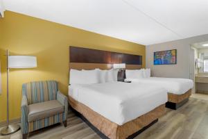 una stanza d'albergo con due letti e una sedia di Best Western Inn Of Palatka a East Palatka Altre 25 foto