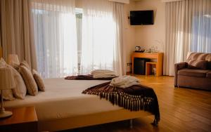 een slaapkamer met een bed en een groot raam bij Hotel Rural Quinta da Conchada in Aguieira +88 foto's