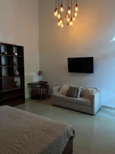 a living room with a couch and a flat screen tv at Hotelito DELI in Mérida