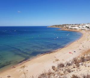 a view of a beach with people in the water at Casa Prainha da Luz in Luz +1 photo