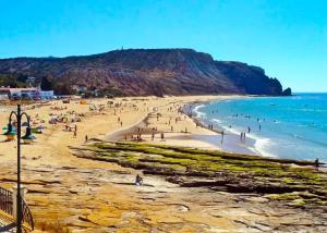 a group of people on a beach near the ocean at Casa Prainha da Luz in Luz