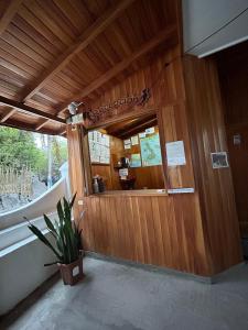 un ristorante con una parete di legno con una finestra di Hostal Brisas Del Mar a Puerto Villamil