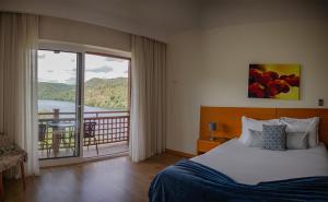 een slaapkamer met een bed en een balkon met uitzicht bij Hotel Rural Quinta da Conchada in Aguieira