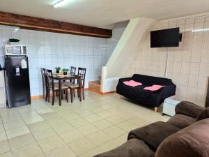 een woonkamer met een tafel en een koelkast bij Departamento bahia fonck in Puerto Montt