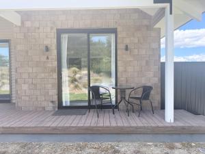 a patio with two chairs and a table on a porch at Guesthouse A in Twizel