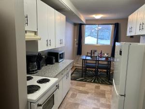 una cucina con un frigorifero bianco e un tavolo di One Bedroom Main floor Apartment a Camrose