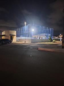 a building lit up at night in a parking lot at Apartamento Condomínio Turu a 6km da Praia in Maioba