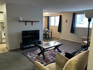 un soggiorno con TV e tavolino da caffè di One Bedroom Main floor Apartment a Camrose