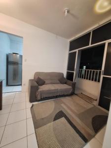 a living room with a couch and a refrigerator at Apartamento Condomínio Turu a 6km da Praia in Maioba +6 photos