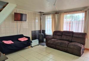 een woonkamer met een bank en een televisie bij Departamento bahia fonck in Puerto Montt