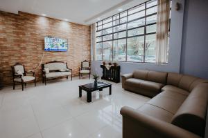 a living room with couches and chairs and a brick wall at Hotel Ermitage in Santana do Livramento