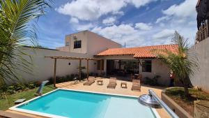 a swimming pool in front of a house at Pousada Carneirinho in Capitólio