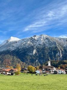 a mountain with a town and a field with a church at Cozy Apartment in Inzell in Inzell