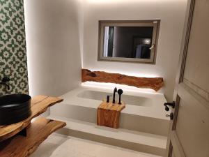 a bathroom with a tub with a mirror and a sink at Masseria Camerlengo in Castellana Grotte +57 photos