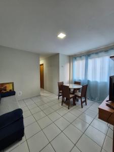 a living room with a table and chairs and a couch at Em condominio in Parnamirim