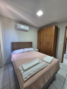 a bedroom with a bed with towels on it at Em condominio in Parnamirim