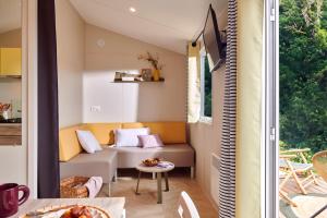 a small living room with a couch and a table at Camping Le Solitaire du Lac in Saint-Jorioz +22 photos