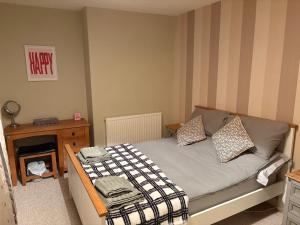 a small bedroom with a bed and a night stand at 13 Chute Street central and homely in Exeter