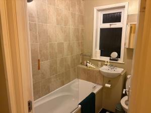 a bathroom with a tub and a sink at 13 Chute Street central and homely in Exeter +6 photos
