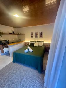 a bedroom with a green bed in a room at Chalés Bermond- Rota da Ferradura in Guarapari +25 photos