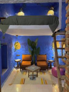 a room with a bunk bed and chairs and a table at Casa Amina in Chefchaouen +73 photos