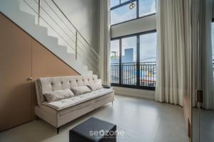 a living room with a couch and a large window at Full Loft 290 m from the Beach CPH0202 in Florianópolis