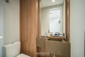 a bathroom with a sink and a toilet and a mirror at Full Loft 290 m from the Beach CPH0202 in Florianópolis +6 photos
