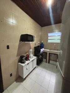 een kleine keuken met een wastafel en een tv bij Casa da Gigi in Arraial do Cabo